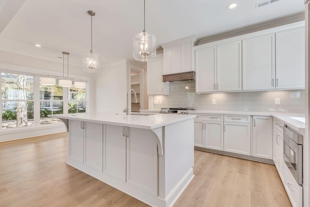 kitchen featuring light countertops, light wood-type flooring, and a sink