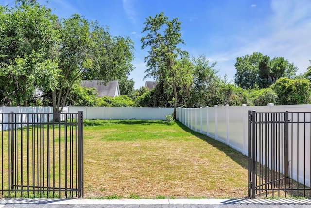 view of yard with a gate and a fenced backyard