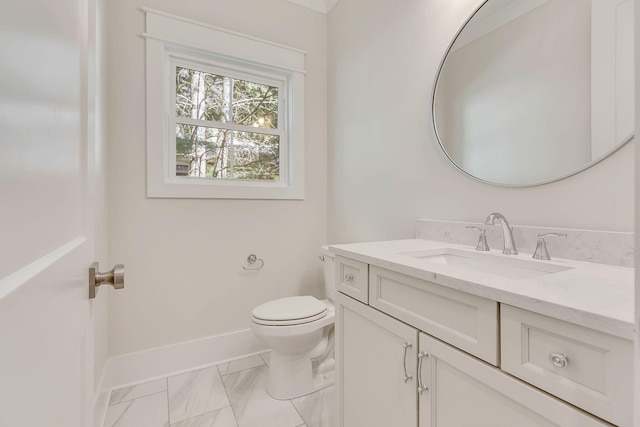 half bath featuring baseboards, vanity, and toilet