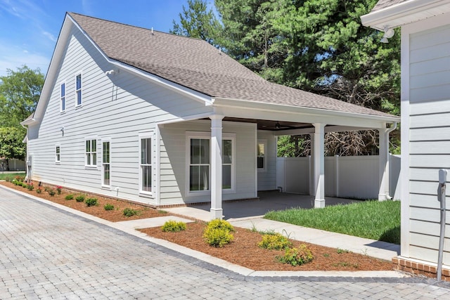 exterior space with a shingled roof and fence