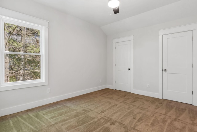 unfurnished bedroom featuring multiple windows, baseboards, and carpet flooring