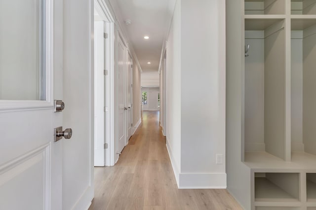 hallway featuring baseboards, recessed lighting, and light wood-style floors