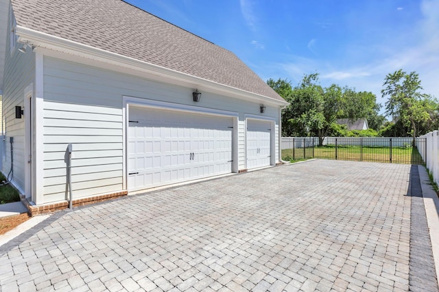 garage with driveway and fence