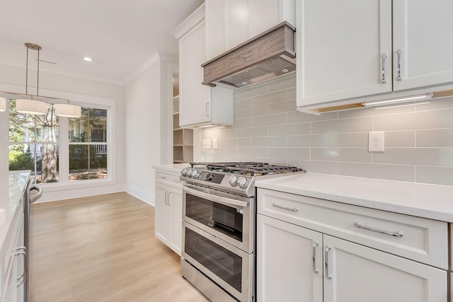 kitchen with stainless steel appliances, tasteful backsplash, light wood-type flooring, and light countertops