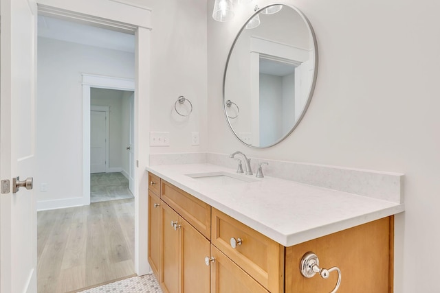 bathroom featuring vanity, baseboards, and wood finished floors