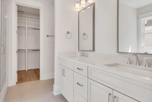 bathroom featuring tile patterned flooring, a sink, and a spacious closet