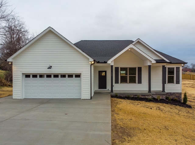 ranch-style home with a garage, concrete driveway, and a shingled roof