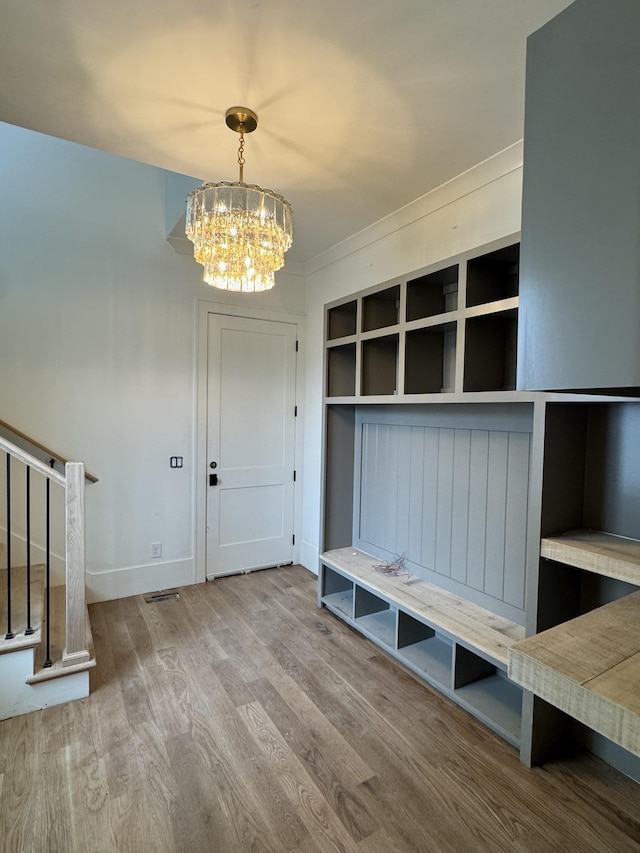 mudroom featuring a notable chandelier, baseboards, and wood finished floors