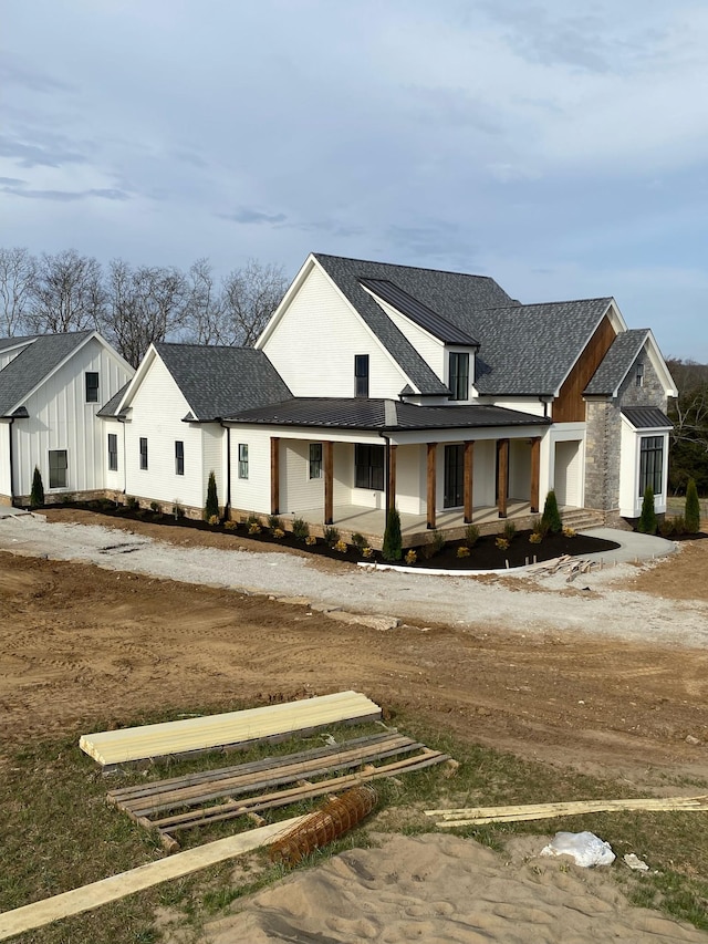 view of front of property with a shingled roof and board and batten siding