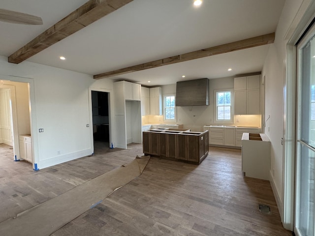 kitchen featuring light wood-style floors, beamed ceiling, recessed lighting, and a center island