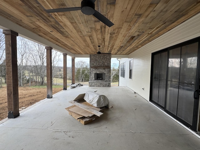 view of patio with an outdoor stone fireplace and ceiling fan