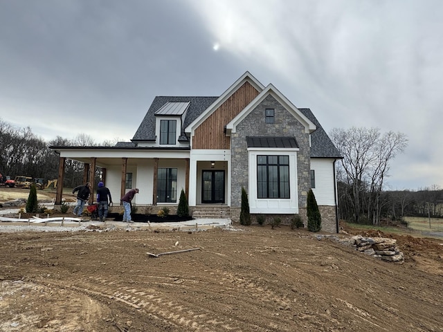 view of front of home with covered porch and roof with shingles