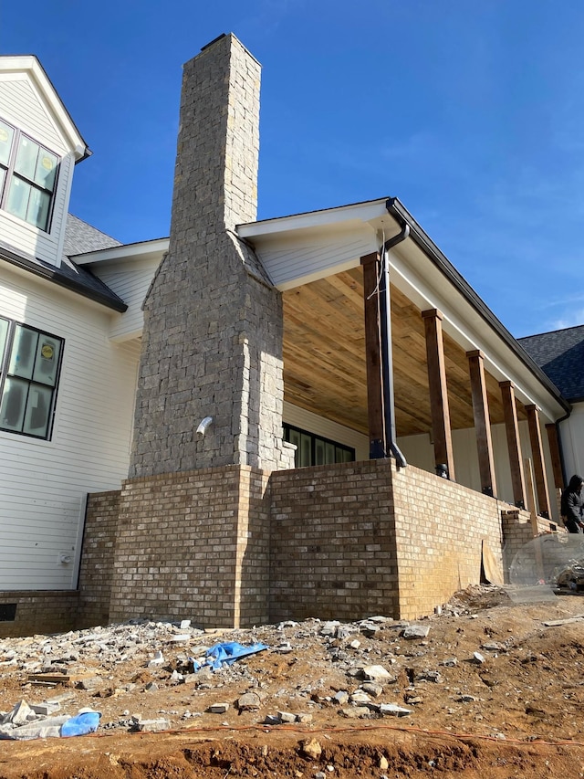 view of side of home with brick siding and a chimney