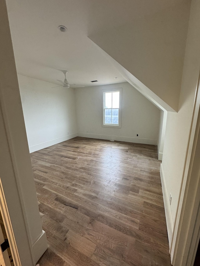 bonus room with a ceiling fan, baseboards, and wood finished floors