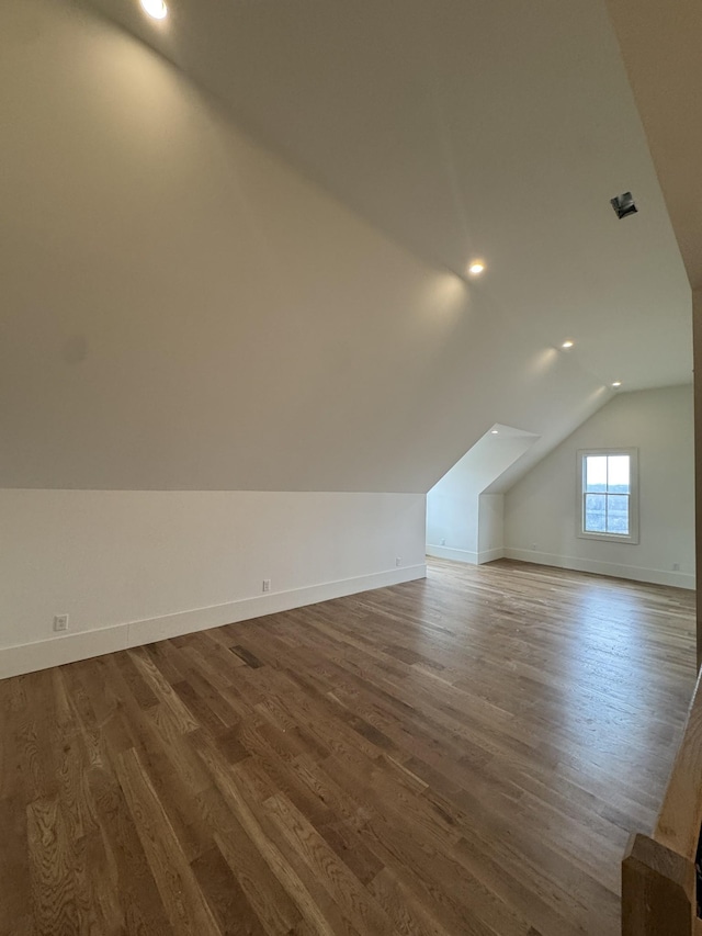 additional living space with lofted ceiling, baseboards, and wood finished floors