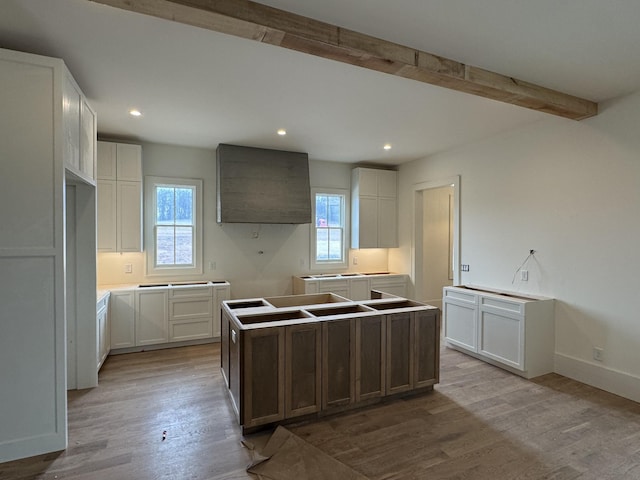 kitchen with a center island, beam ceiling, recessed lighting, and wood finished floors