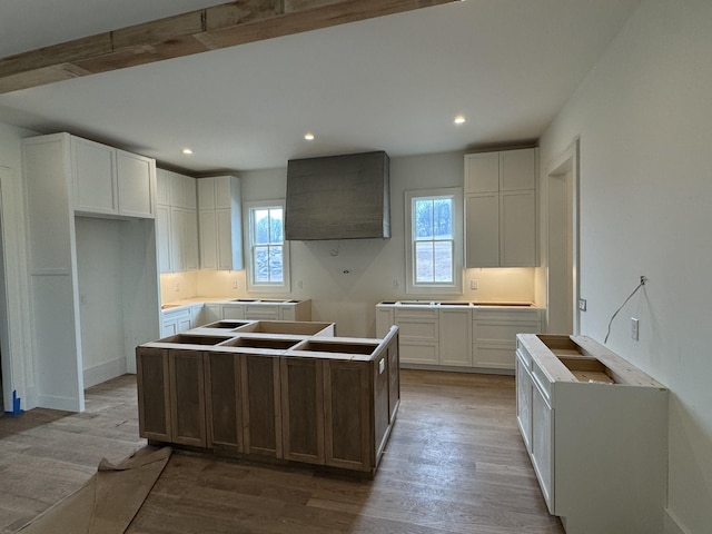 kitchen featuring recessed lighting, wood finished floors, white cabinetry, and a center island