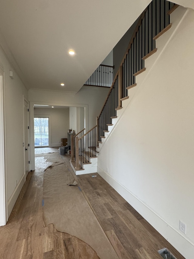 interior space with recessed lighting, wood finished floors, baseboards, and stairs