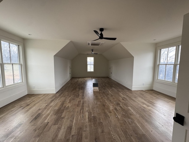 bonus room with visible vents, vaulted ceiling, baseboards, and wood finished floors