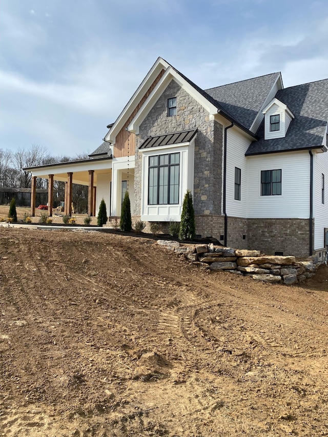 modern inspired farmhouse featuring crawl space, stone siding, and a shingled roof