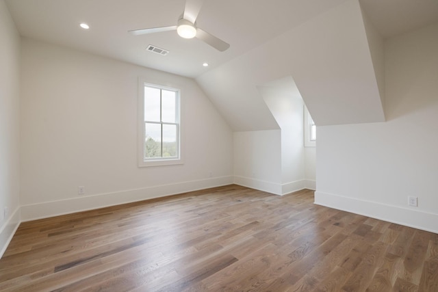 additional living space with baseboards, visible vents, wood finished floors, and ceiling fan