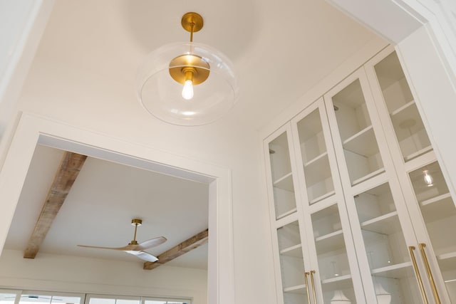 room details featuring beamed ceiling and ceiling fan