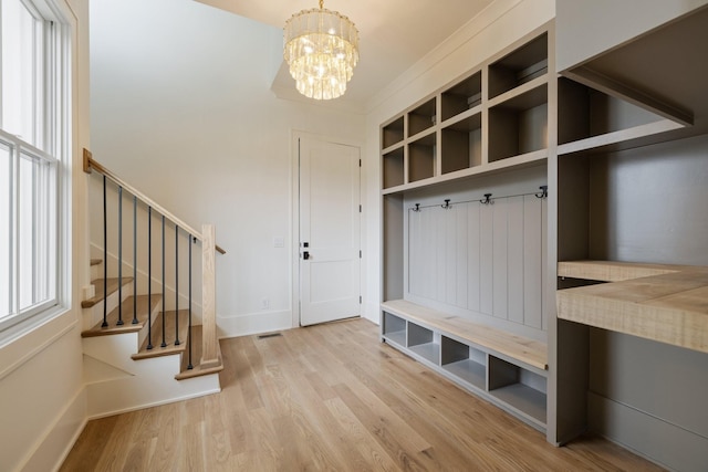mudroom with baseboards, visible vents, wood finished floors, and a notable chandelier