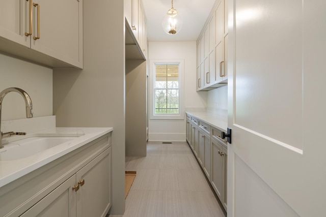 interior space with baseboards, light countertops, and a sink