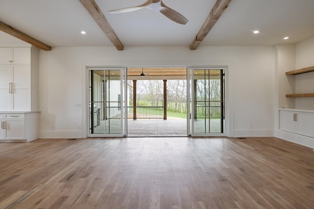 unfurnished living room featuring light wood-type flooring, beam ceiling, baseboards, and ceiling fan