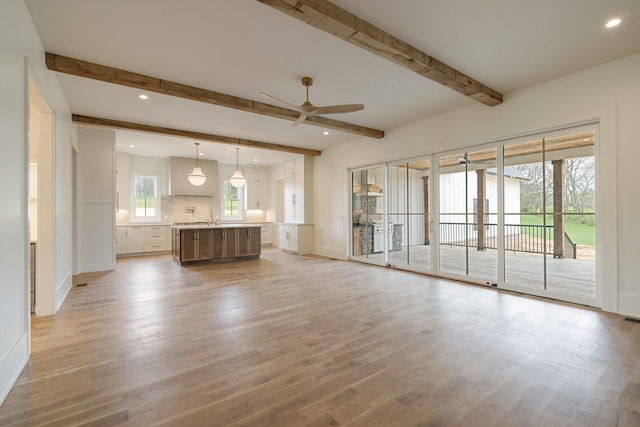 unfurnished living room with visible vents, beamed ceiling, ceiling fan, recessed lighting, and light wood-type flooring