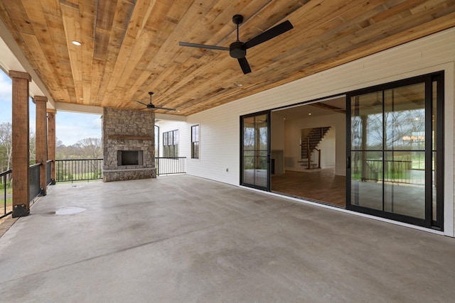 view of patio / terrace featuring an outdoor stone fireplace and a ceiling fan
