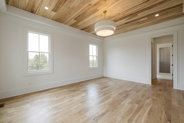 spare room featuring light wood-style flooring, baseboards, and wooden ceiling