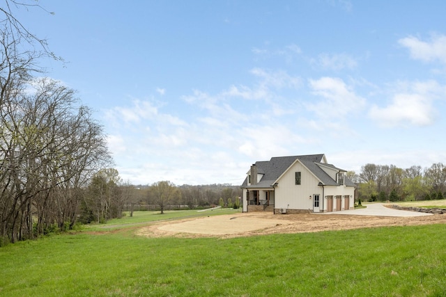 view of yard with an attached garage and concrete driveway