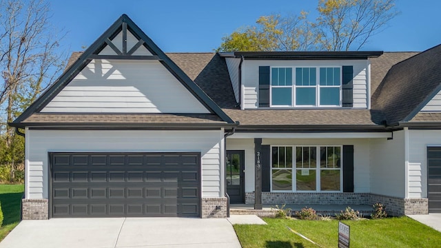 view of front of house with a shingled roof, concrete driveway, an attached garage, covered porch, and brick siding