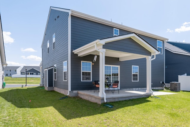 rear view of house featuring a patio area, a lawn, and central air condition unit