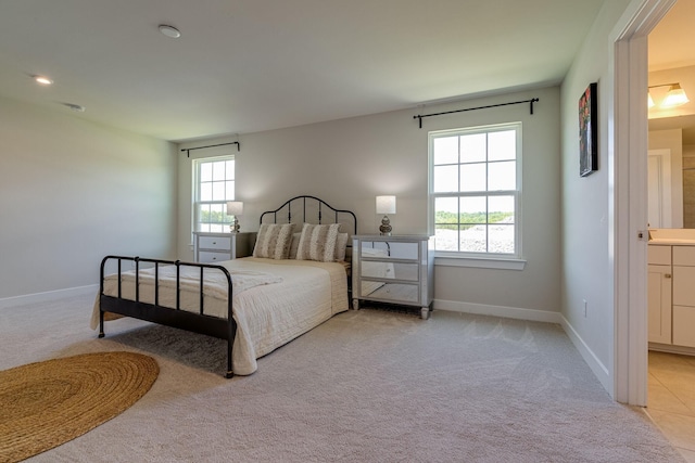 bedroom featuring light colored carpet, multiple windows, and baseboards