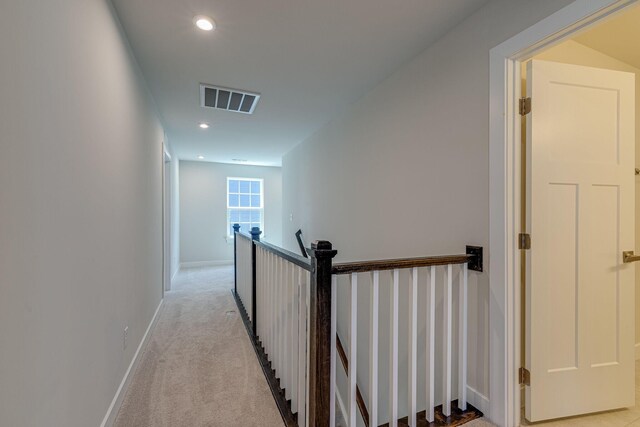 hall featuring light carpet, baseboards, visible vents, an upstairs landing, and recessed lighting