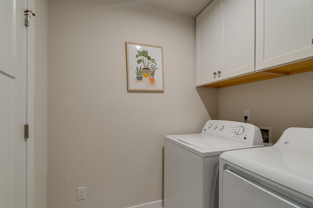 clothes washing area with independent washer and dryer and cabinet space