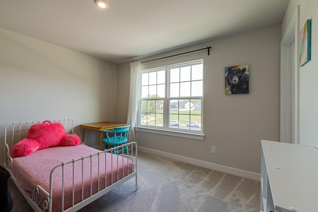 bedroom featuring light carpet and baseboards