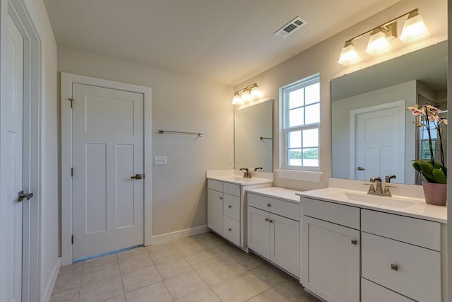 full bathroom with tile patterned flooring, two vanities, a sink, visible vents, and baseboards