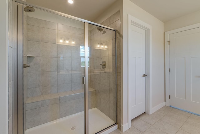 full bathroom featuring a stall shower, tile patterned flooring, and baseboards