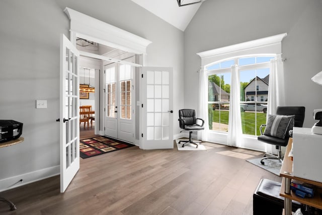 entrance foyer featuring baseboards, high vaulted ceiling, wood finished floors, and french doors