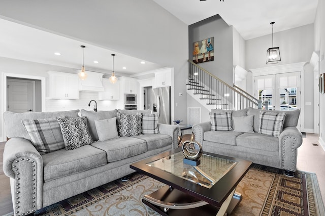 living room featuring recessed lighting, wood finished floors, visible vents, french doors, and stairway