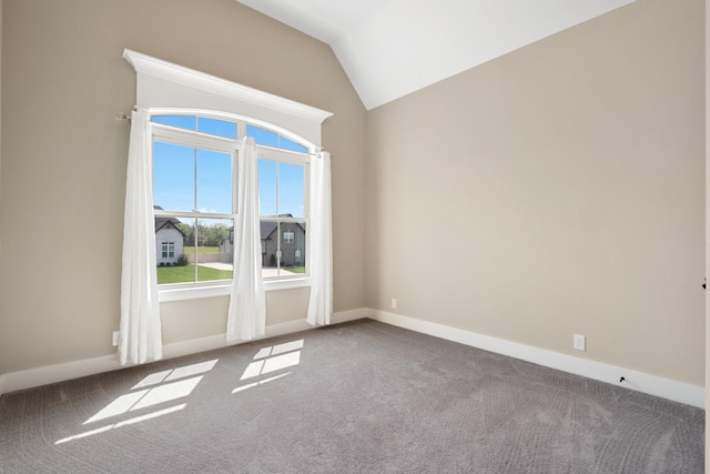 carpeted empty room with lofted ceiling and baseboards