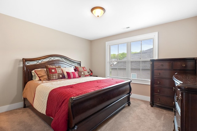 bedroom with light carpet, visible vents, and baseboards