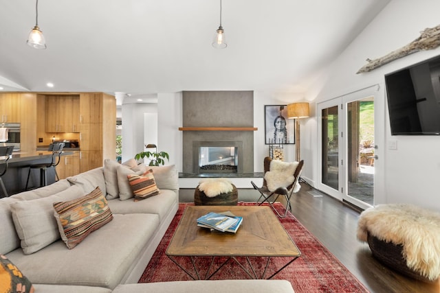 living room with recessed lighting, vaulted ceiling, dark wood-type flooring, and a multi sided fireplace