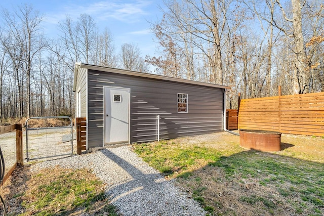 view of outbuilding with an outdoor structure, fence, and a gate