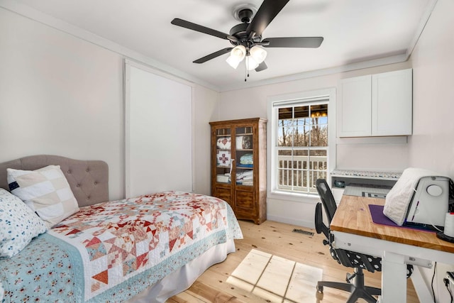 bedroom with a ceiling fan, light wood-type flooring, and crown molding