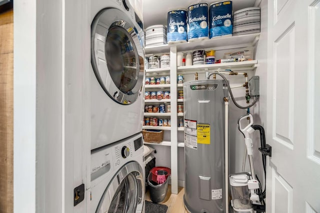 washroom with stacked washer / dryer, laundry area, and water heater