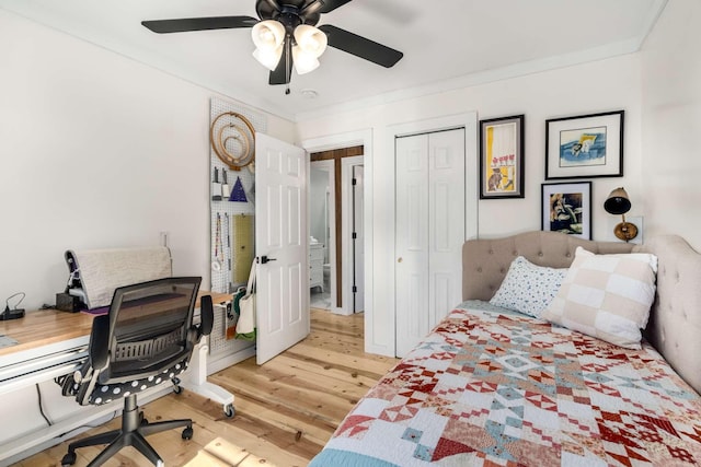 bedroom featuring a closet, crown molding, light wood-style flooring, and ceiling fan